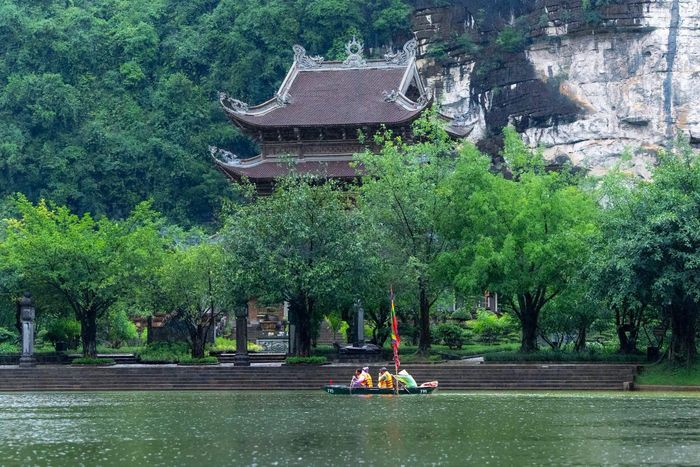  Du khách đội mưa tham quan tuyến tạm thời tại khu du lịch sinh thái Tràng An, tỉnh Ninh Bình, sáng 16/9. Ảnh: Di sản Tràng An.
