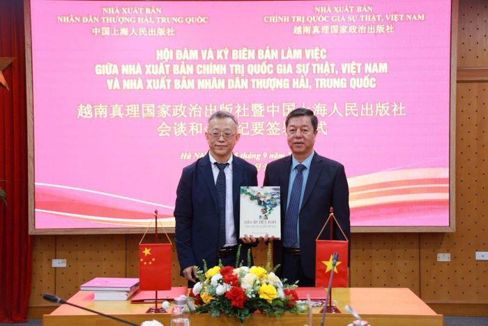  PGS.TS Vũ Trọng Lâm (phải) tặng ấn phẩm kỷ niệm cho ông Ôn Trạch Viễn trong hội đàm. 