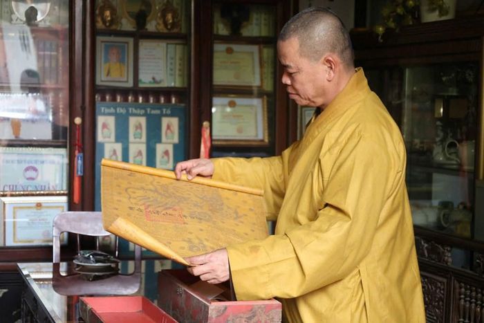 Thượng tọa Thích Như Tiến, Trụ trì chùa Hoa Sơn, giới thiệu những sắc phong được lưu giữ tại chùa
