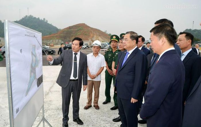 Phó Thủ tướng Thường trực Phạm Gia Túc nghe các đơn vị báo cáo khi khảo sát thực địa tình hình triển khai dự án mở rộng đường vận chuyển hàng hóa chuyên dụng khu vực mốc 1119-1120 - Ảnh: chinhphu.vn/Phương Nguyên