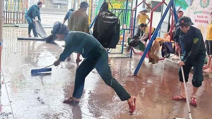 Lực lượng dân quân xã Trường Lâm trợ giúp trường học quét dọn bùn đất do ngập nước. (Ảnh: Ban chỉ huy quân sự xã Trường Lâm)