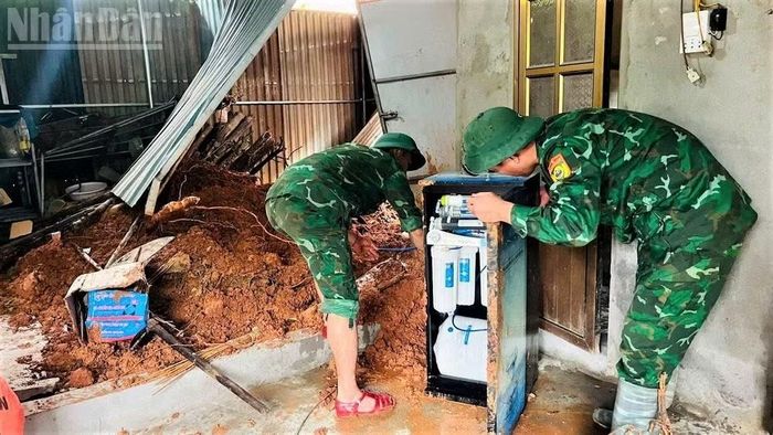 Cán bộ, chiến sĩ Đồn Biên phòng Tam Quang, Bộ đội Biên phòng Nghệ An hỗ trợ các hộ dân di dời tài sản do bị đất sạt lở.