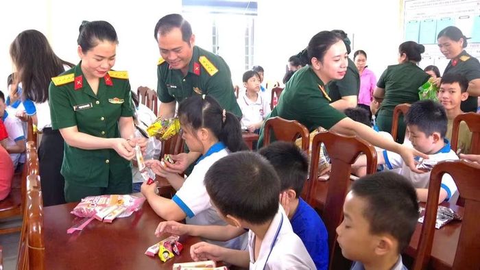 Các cô chú bộ đội trao quà cho từng cháu (Ảnh: HG)