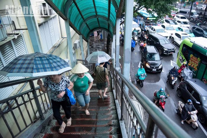 Dù mưa lớn và giao thông chậm, các dòng xe vẫn liên tục dịch chuyển. Người dân cố gắng thích ứng với điều kiện thời tiết và giao thông để trở về nhà.