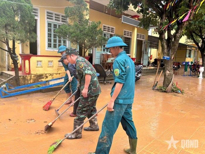  Bộ đội, dân quân giúp các trường học ở xã Ba Lòng dọn vệ sinh sau lũ.