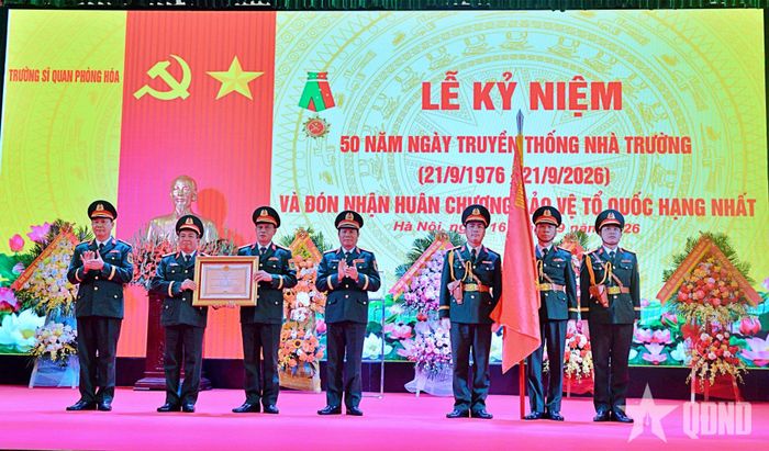 Thừa ủy quyền của Chủ tịch nước, Đại tướng Nguyễn Tân Cương gắn Huân chương Bảo vệ Tổ quốc hạng Nhất lên Quân kỳ Quyết thắng tặng Trường Sĩ quan Phòng hóa. 
