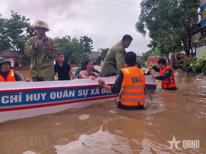 Ban CHQS xã Đông Hiếu sử dụng phương tiện di dời người dân vùng ngập sâu đến nơi an toàn.  