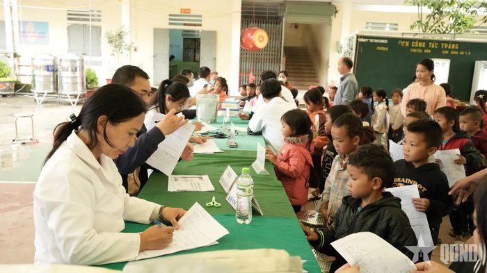 Cán bộ y tế tiếp nhận, kiểm tra thông tin khi khám sức khỏe cho học sinh Trường Phổ thông Dân tộc nội trú liên cấp Tiểu học và THCS Sơn Vĩ. 