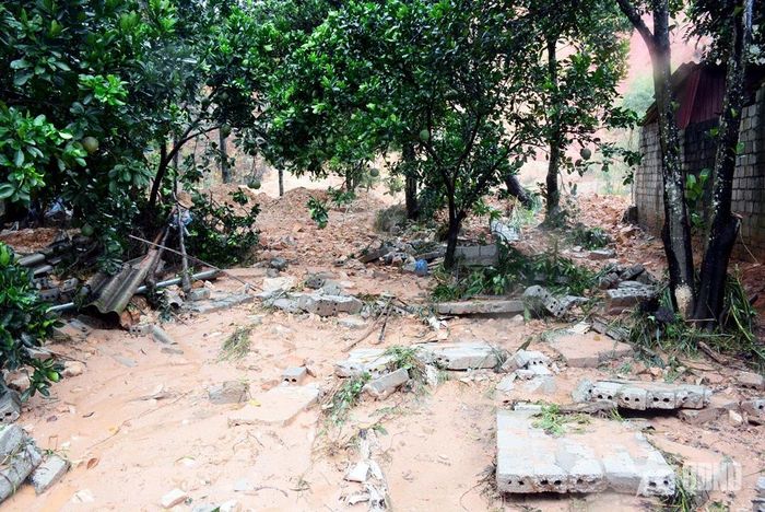 Bùn đất xô đổ tường rào, tràn vào sân vườn nhà bà Nguyễn Thị Lợi. 