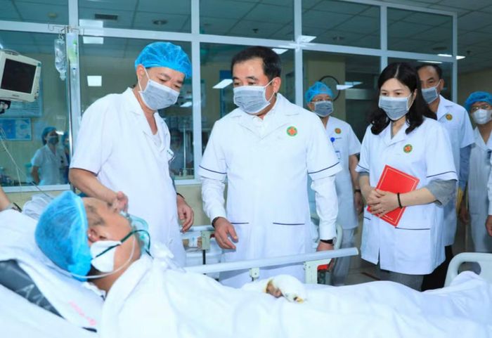 Bí thư Thành ủy Hà Nội Trần Đức Thắng thăm hỏi nạn nhân đang điều trị tại Bệnh viện Quân y 354. Ảnh: QUANG THÁI