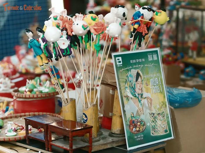 Trong không khí rực rỡ của chợ Trung thu phố cổ, những gian hàng đồ chơi truyền thống tạo nên một sắc màu riêng giữa phố Hàng Mã. Dù không quá lớn nhưng gian hàng tò he vẫn khiến nhiều người dừng lại quan sát những hình thù được tạo nên từ những khối bột màu.