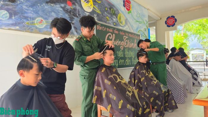Đoàn viên, thanh niên Đồn Biên phòng Phước Tỉnh và thợ cắt tóc tổ chức cắt tóc miễn phí cho các em học sinh. Ảnh: Văn Danh