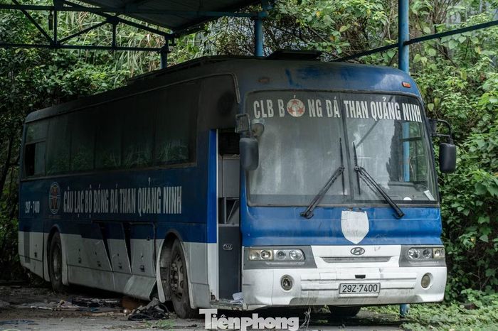 Chiếc xe 45 chỗ được trang trí với tông màu xanh - trắng truyền thống từng đưa các cầu thủ CLB Than Quảng Ninh đi chinh phục cột mốc đỉnh cao trong bóng đá, giờ nằm im lìm trong góc sân và đang dần xuống cấp, hư hỏng sau nhiều năm không sử dụng.