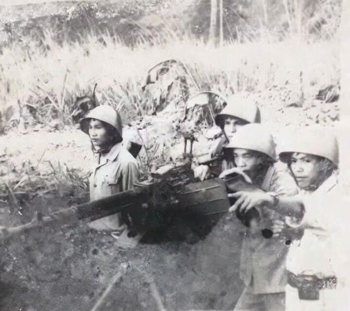 Ông Phạm Tiến (ngoài cùng bên phải) chỉ thị mục tiêu cho khẩu 12,7mm trên chốt đồi Dài năm 1979. Ảnh: NVCC.