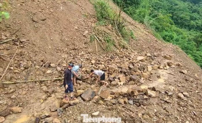 Đất đá từ taluy tràn xuống mặt đường sau mưa lớn, khiến việc di chuyển của người dân và học sinh thêm khó khăn. Theo người dân địa phương, nhiều đoạn đường từ bản ra trung tâm xã chỉ vừa đủ cho xe máy đi qua. Nhiều đoạn đất đá sạt lở chắn lối, người dân phải vừa đi vừa dẹp đá mở đường.