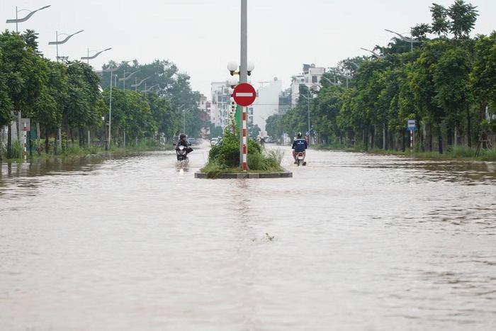 Tại đường Nguyễn Gia Bồng, đoạn gần công viên Ngọc Thụy, nước từ nhiều hướng dồn về khiến tuyến đường ngập nặng và rút chậm.