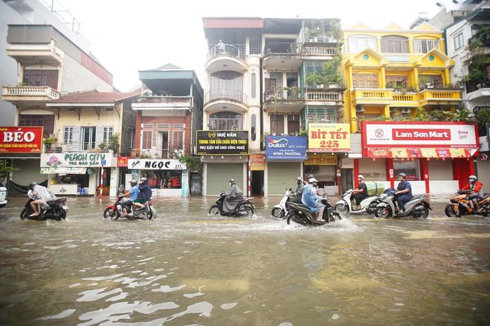 Sau 2 ngày mưa, phố Ngọc Lâm mênh mông nước, nước tràn sát vỉa hè và khu vực trước các cửa hàng hai bên phố.