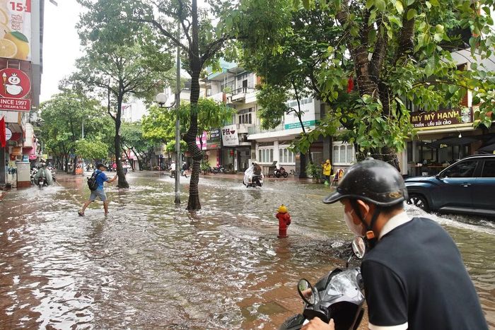 Ngập úng ảnh hưởng đến hoạt động kinh doanh hai bên phố, nhiều cửa hàng phải đóng cửa để tránh nước tràn vào nhà.