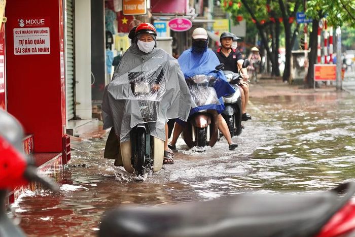 Xe máy nối đuôi nhau di chuyển trên vỉa hè để tránh đoạn đường ngập.