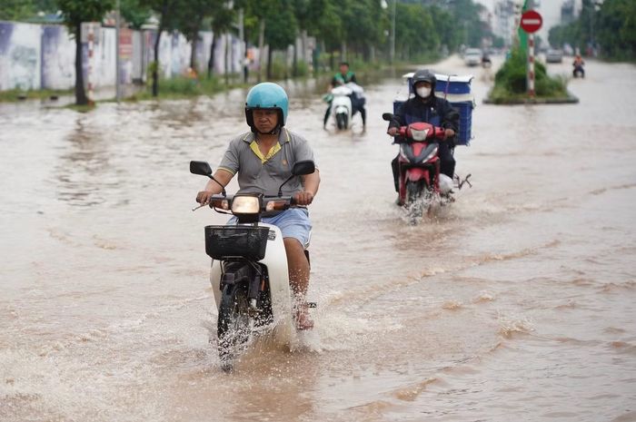 Người điều khiển xe máy phải giảm tốc, di chuyển sát dải phân cách để tránh những đoạn ngập sâu.