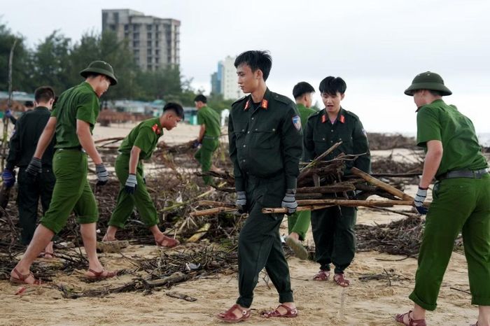 Các chiến sĩ công an dọn rác trên bãi biển Nhật Lệ.