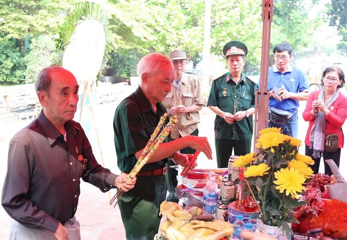 Ông Huỳnh Văn Cấn (bìa trái) dâng hương kính viếng anh linh đồng đội. Ảnh: Ngô Tùng