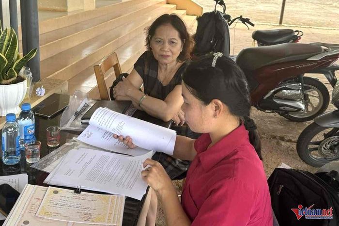 Chị Trang đang xem hồ sơ của thanh niên tình nguyện nhập ngũ. Ảnh: Hải Dương
