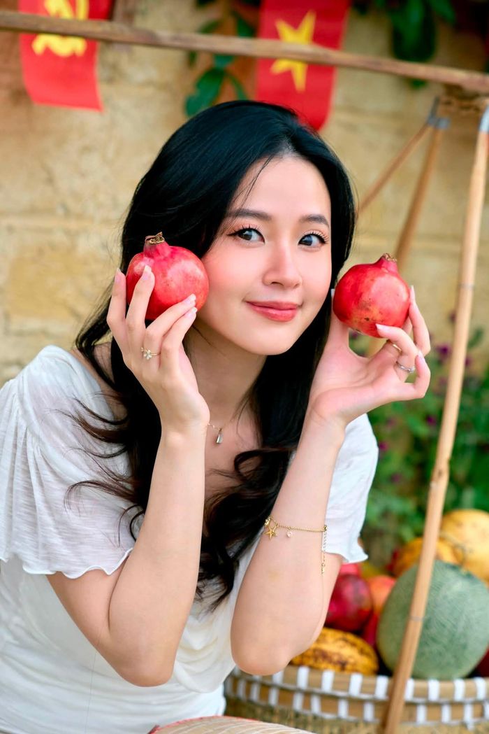 Diễn viên Midu tạo dáng bên gánh trái cây.