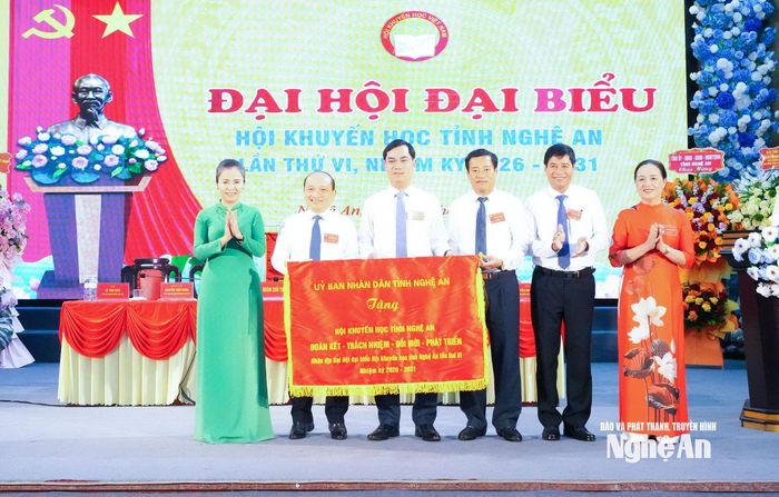 Đồng chí Võ Thị Minh Sinh – Phó Bí thư Tỉnh ủy, Chủ tịch Ủy ban MTTQ Việt Nam tỉnh trao tặng Hội Khuyến học tỉnh Nghệ An bức trướng mang dòng chữ "Hội Khuyến học tỉnh Nghệ An: Đoàn kết - trách nhiệm - đổi mới, phát triển". Ảnh: Mai Hoa
