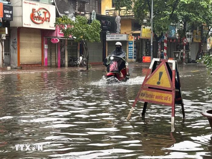 Sáng 16/9, ngập úng xảy ra trên phố Ngọc Lâm (Hà Nội), khiến việc đi lại của người dân gặp nhiều khó khăn. (Ảnh: Minh Quyết/TTXVN)