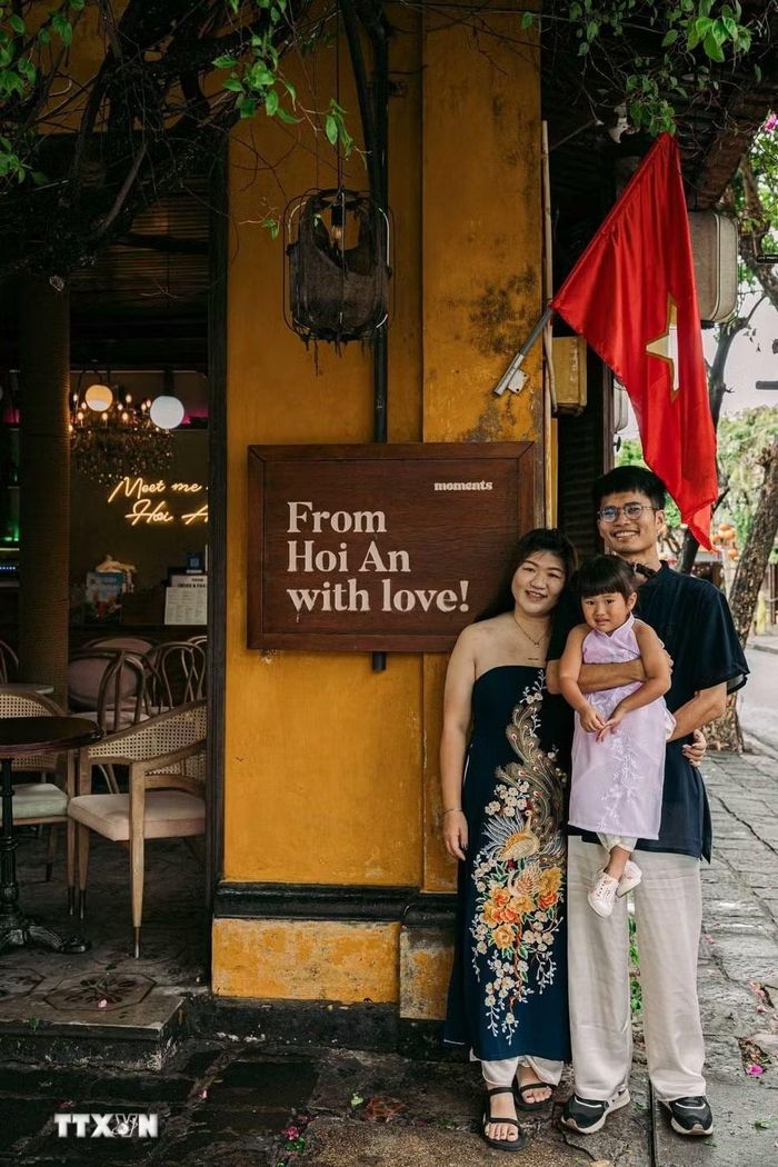 Du khách lưu lại kỷ niệm bên bức tường đặc trưng của phố cổ Hội An. (Ảnh: Phạm Tuấn Anh/TTXVN)