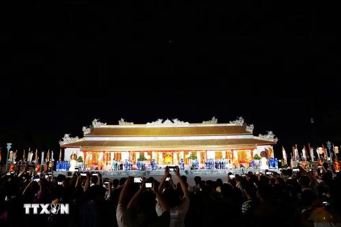 Du khách xem tái hiện sân khấu hóa Lễ Thiết triều trong Đại Nội Huế về đêm. (Ảnh: Nguyên Lý/TTXVN)