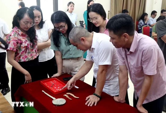 Nhiều đồ tùy táng được phát hiện, gồm bình, chén, bát, nồi, vò, lọ bằng gốm sành; tiền Ngũ Thù; dao, đao, kiếm bằng sắt; đồ đồng; hạt chuỗi thủy tinh và các hạt, lá kim loại màu vàng. (Ảnh: Văn Tý/TTXVN)