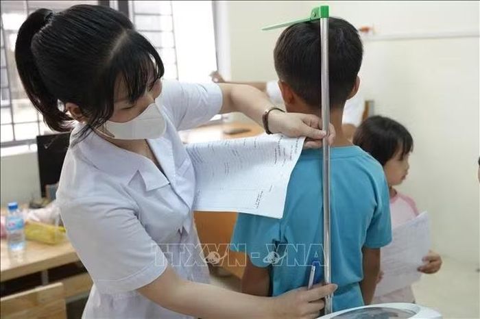 Đo chiều cao cho học sinh.