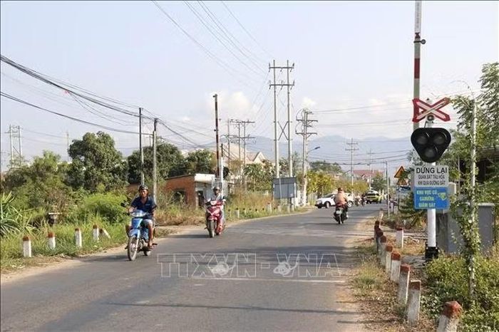Một tuyến đường ngang giao cắt qua đường sắt có đèn và biển cảnh báo an toàn giao thông.