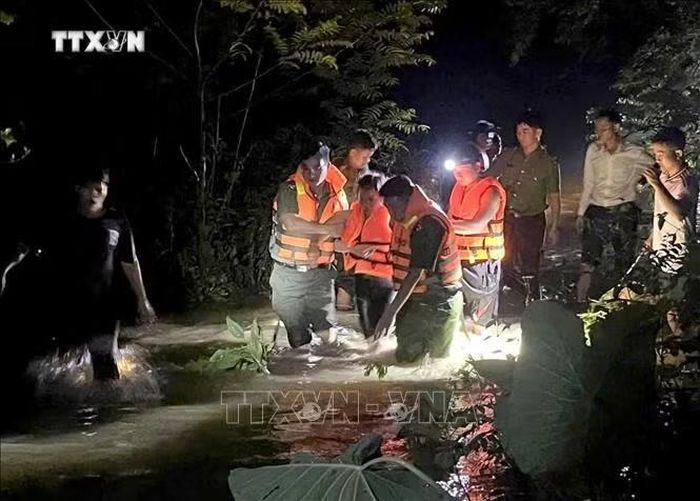 Công an xã Tam Thái cùng Ban Chỉ huy quân sự xã, lực lượng dân quân tự vệ và lực lượng tham gia bảo vệ an ninh, trật tự ở cơ sở hỗ trợ chị Vi Thị S. (38 tuổi, trú tại bản Phồng, xã Tam Thái) bị đau ruột thừa, vượt qua khu vực ngập lụt để đi cấp cứu trong đêm. Ảnh: TTXVN phát