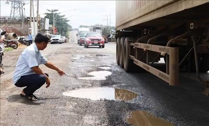 Anh Võ Trọng Hiệp, Trưởng khu phố Tân Xuân 1, phường Bình Phước chỉ những vị trí mặt đường Nguyễn Huệ hư hỏng, tiềm ẩn nguy cơ mất an toàn đối với học sinh Trường Tiểu học Tân Xuân vào giờ đưa đón.