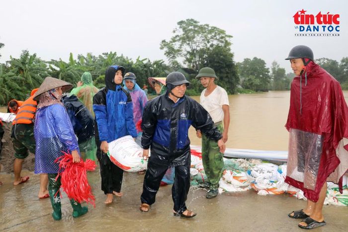 Các chiến sĩ cùng bà con xã Xuân Mai dùng bao tải cát gia cố các tuyến đê bị tràn.