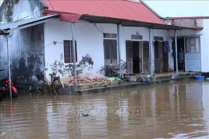 Nước ngập gần lên đến nhà của người dân thôn Tây Thành, xã Quỹ Nhất. Ảnh: Công Luật/TTXVN