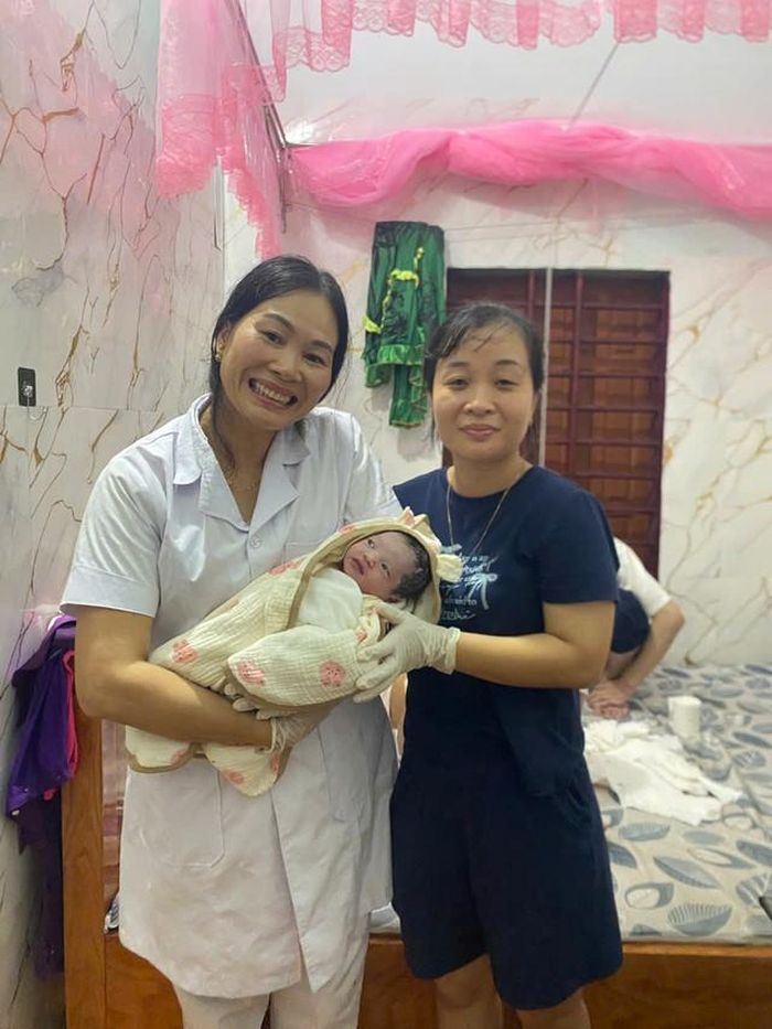 Hai nhân viên y tế vượt lũ đến nhà sản phụ đã đỡ đẻ thành công. (Ảnh: nhân vật cung cấp)