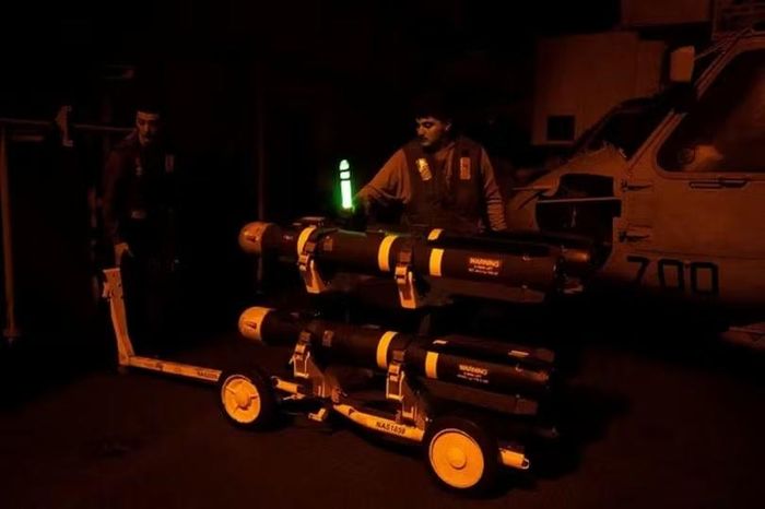 Nhân viên kỹ thuật lắp bom tấn công chính xác lên máy bay trên tàu sân bay để tấn công Iran. Ảnh: Reuters.