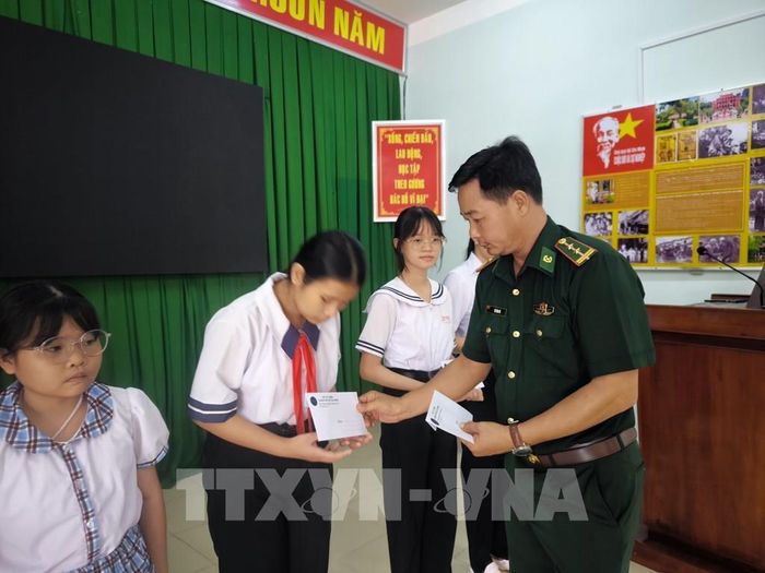 Đồn Biên phòng Hàm Luông tặng học bổng cho học sinh vào năm học mới. Ảnh: Huỳnh Phúc Hậu - TTXVN