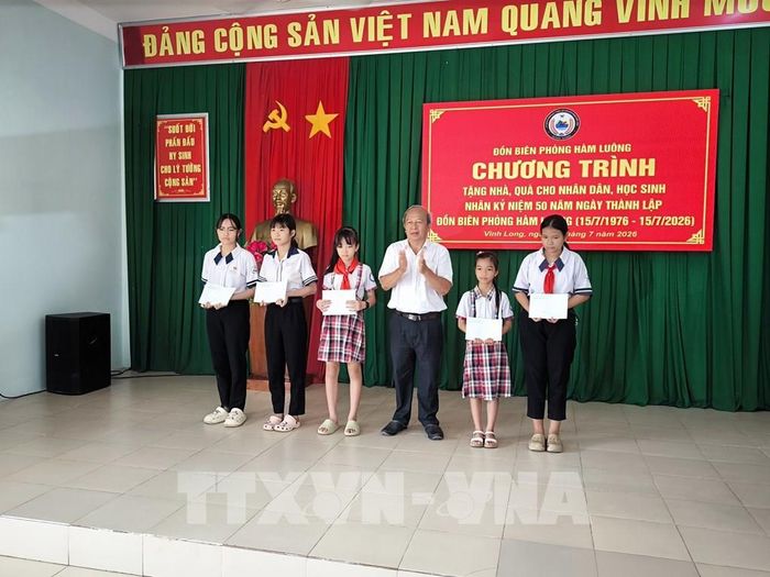 Đồn Biên phòng Hàm Luông tặng học bổng cho học sinh thuộc chương trình "Nâng bước em tới trường". Ảnh: Huỳnh Phúc Hậu - TTXVN
