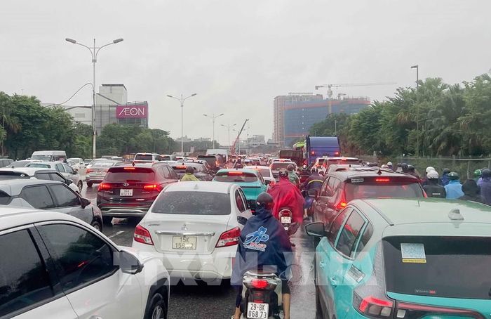 Các phương tiện nối đuôi nhau nhích từng mét do ùn tắc cục bộ trên đường Đàm Quang Trung (phường Long Biên), đoạn từ cầu vượt Vĩnh Tuy đến ngã tư Cổ Linh - Đàm Quang Trung do ngập và các công trình đang thi công. Ảnh: Phan Phương – TTXVN