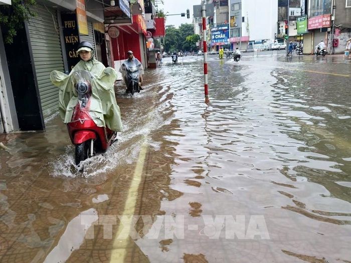 Ngập úng trên phố Ngọc Lâm, phường Bồ Đề khiến việc đi lại của người dân gặp nhiều khó khăn. Ảnh: Minh Quyết – TTXVN