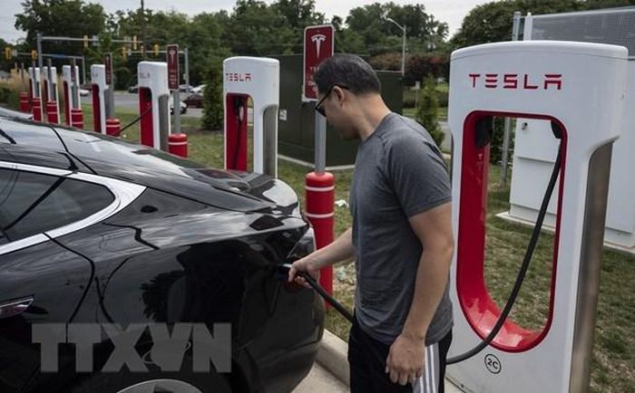 Người dân sạc điện cho ô tô tại một trạm sạc của Tesla ở Arlington, Virginia, Mỹ. Ảnh: AFP/TTXVN
