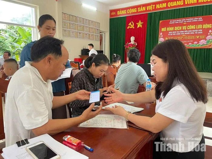 Cán bộ tổ dịch vụ công lưu động phường Sầm Sơn hướng dẫn người dân thực hiện các thủ tục hành chính.