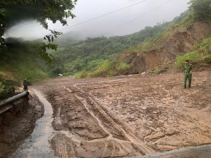 Trên Quốc lộ 15 qua bản Cặt, xã Nhi Sơn, bùn đất từ ta luy dương sạt xuống gây ách tắc giao thông. . Ảnh: CA xã Pù Nhi