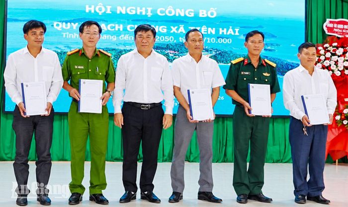 Bí thư Đảng ủy, Chủ tịch UBND xã Tiên Hải Mai Quốc Thắng trao hồ sơ quy hoạch cho các đơn vị.