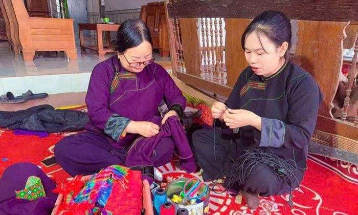  Bí thư Chi bộ Vi Thị Hằng (bên phải) cùng người dân may trang phục truyền thống của đồng bào dân tộc Nùng. 
